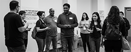 A diverse group of empowered individuals, including young adults and community members, gathered in a bright space, engaging in a discussion about justice reform, re-entry support, and community empowerment. The scene reflects unity, collaboration, and the movement for lasting change.